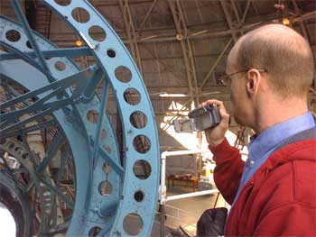 Phil Plait atop the telescope service gantry, peering into the primary mirror.